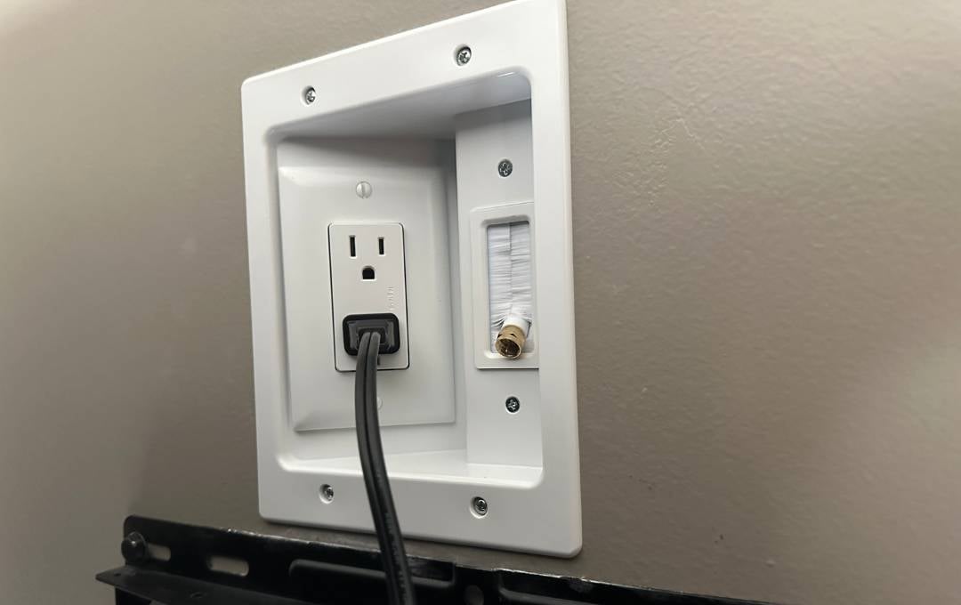 TV mounted on the wall with an tv electrical outlet with cable chase way 