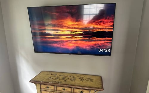 TV mounted on the wall with an tv electrical outlet