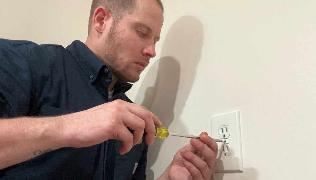 electrician installing electrical outlet